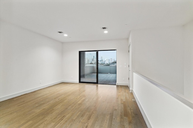 unfurnished room featuring visible vents, baseboards, and light wood-style flooring