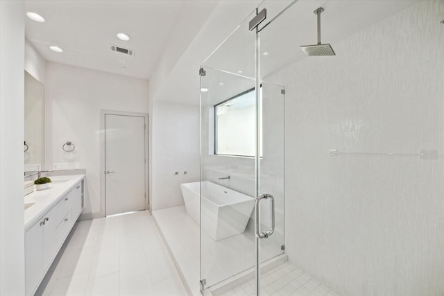 full bathroom with double vanity, a freestanding tub, visible vents, and a stall shower