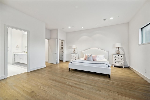 bedroom with recessed lighting, light wood-type flooring, visible vents, and ensuite bath