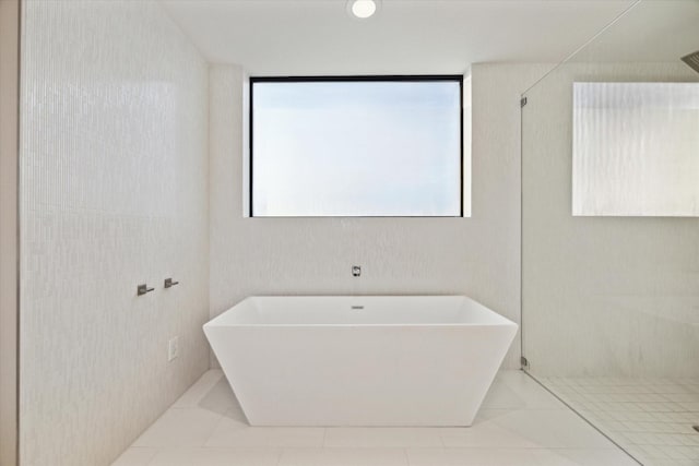 bathroom featuring a shower, a freestanding tub, and tile patterned flooring