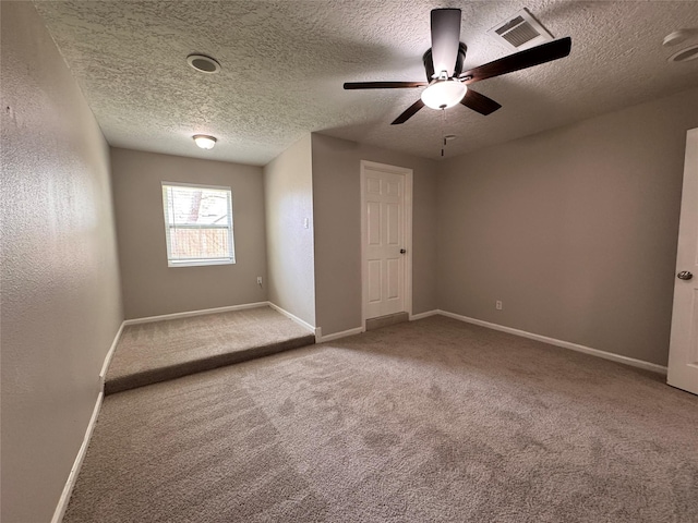 empty room featuring visible vents, baseboards, and carpet floors