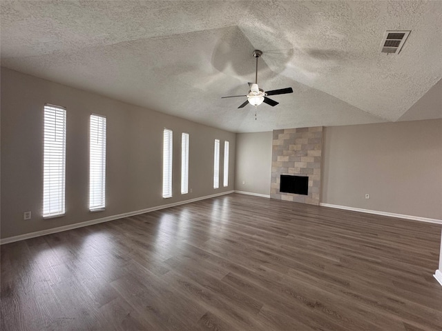 unfurnished living room featuring vaulted ceiling, visible vents, a fireplace, and dark wood-style flooring