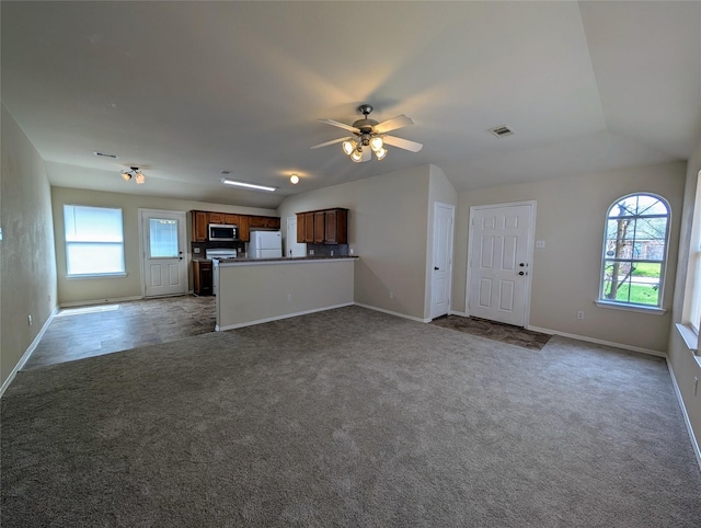 unfurnished living room with a ceiling fan, baseboards, visible vents, lofted ceiling, and carpet flooring