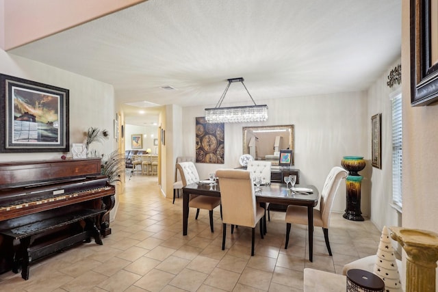 dining area featuring visible vents, an inviting chandelier, and light tile patterned flooring