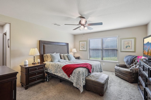 carpeted bedroom with visible vents and a ceiling fan