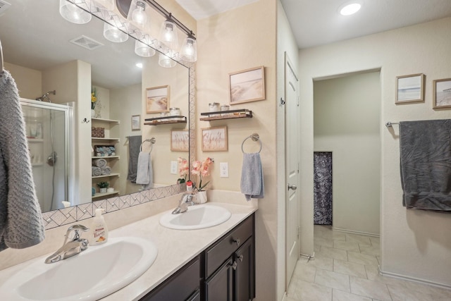 bathroom featuring double vanity, visible vents, a stall shower, and a sink