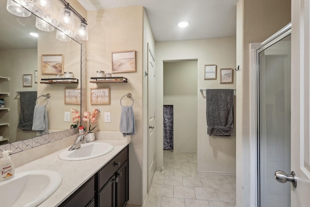 bathroom featuring double vanity, baseboards, a shower with door, and a sink