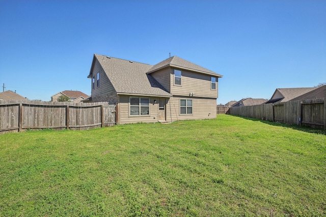 back of house with a lawn and a fenced backyard