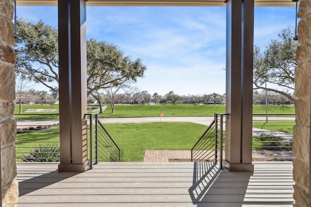 deck with a rural view and a yard