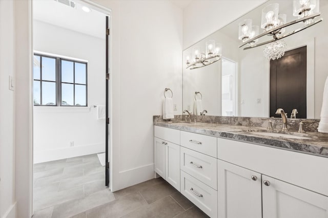 full bathroom with double vanity, tile patterned flooring, baseboards, and a sink