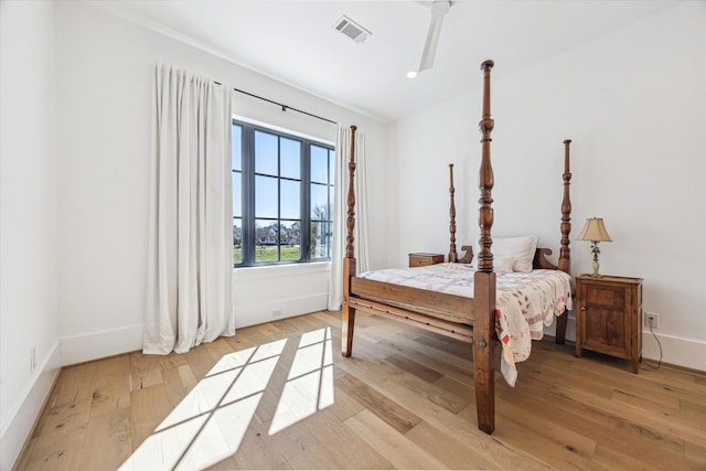 bedroom featuring visible vents, ceiling fan, baseboards, and light wood-style floors