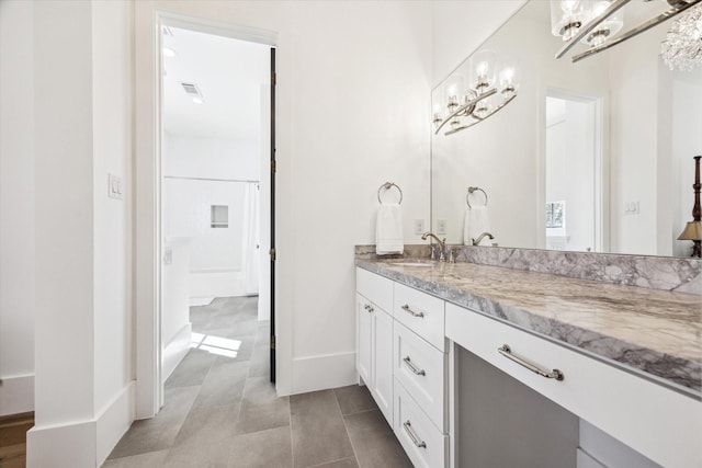 bathroom featuring tile patterned flooring, visible vents, vanity, and baseboards