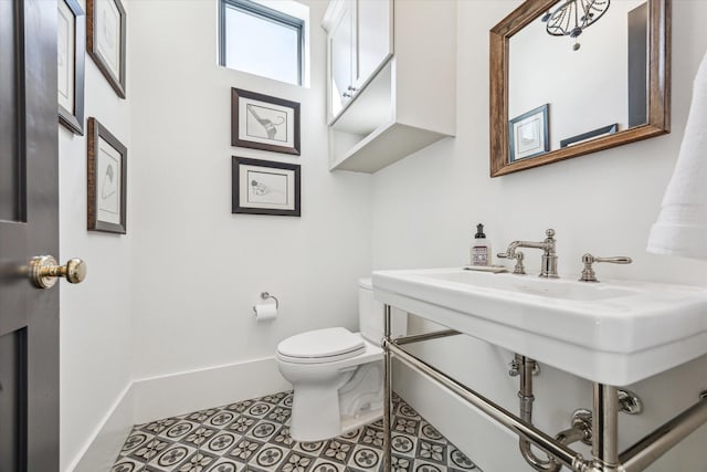 bathroom featuring tile patterned floors, baseboards, and toilet