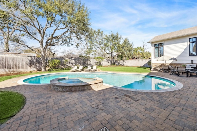 view of swimming pool featuring a patio, a yard, a fenced backyard, and a pool with connected hot tub