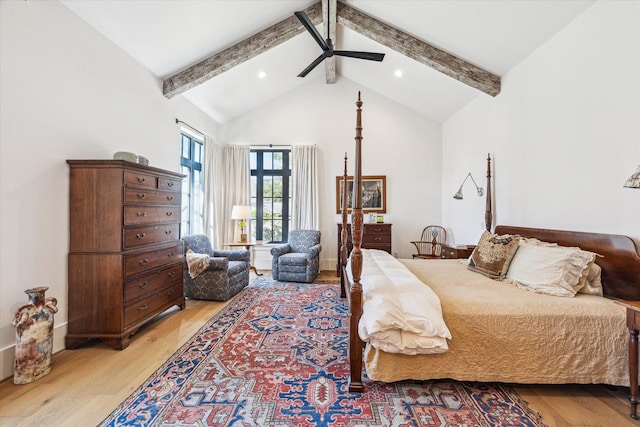 bedroom featuring beam ceiling, high vaulted ceiling, and light wood-style flooring