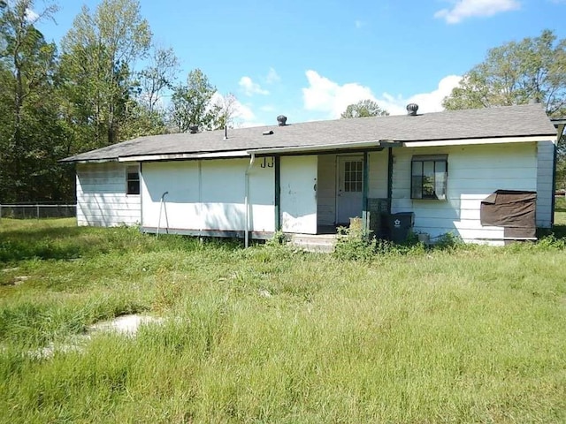 rear view of property featuring fence