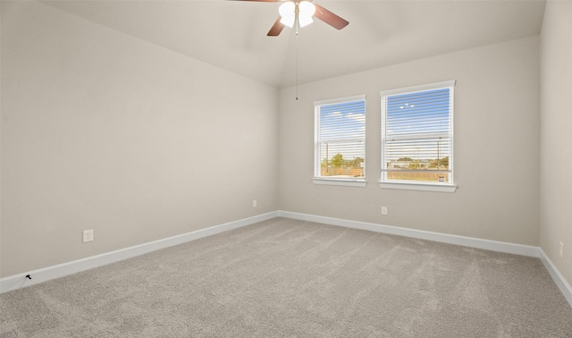 unfurnished room with light carpet, a ceiling fan, baseboards, and vaulted ceiling