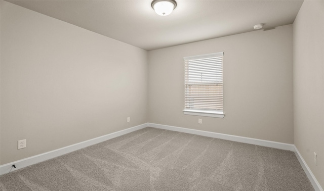 carpeted empty room with baseboards