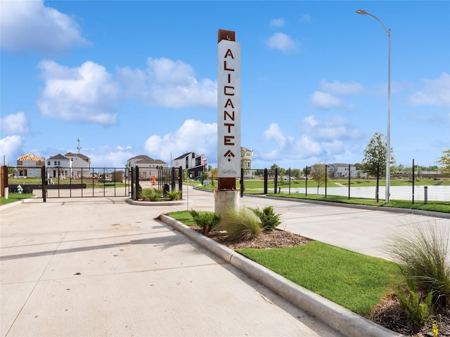 13109 Mundet Dr, Houston, TX 77047 - view of concrete street with a gate, curbs, street lights, and a gated entry
