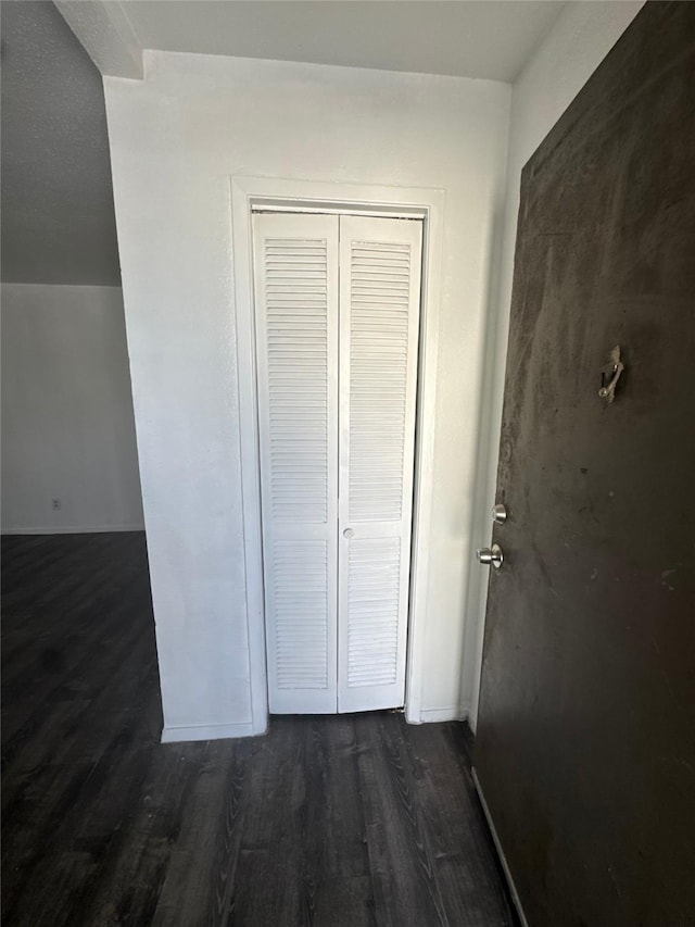 hallway with baseboards and dark wood-type flooring