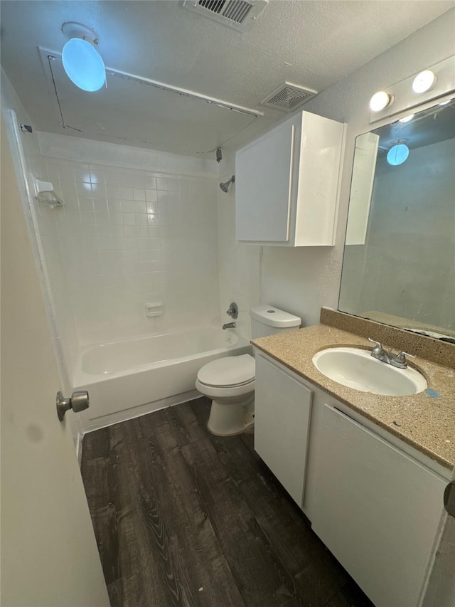 bathroom featuring vanity, wood finished floors, visible vents, bathtub / shower combination, and toilet