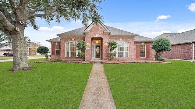 view of front of house with brick siding and a front lawn