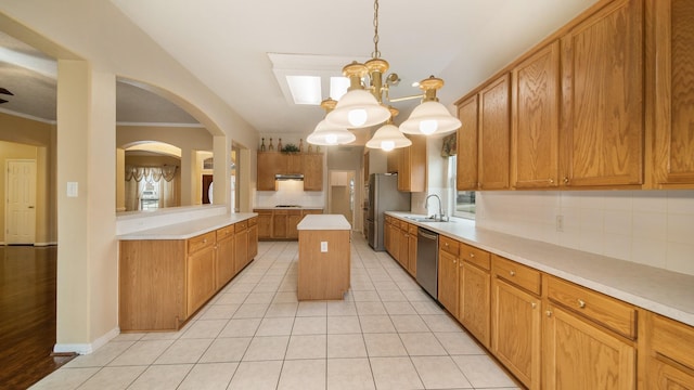 kitchen featuring light tile patterned floors, a sink, stainless steel appliances, light countertops, and under cabinet range hood