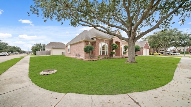 view of front of house with a front lawn, brick siding, concrete driveway, and an attached garage