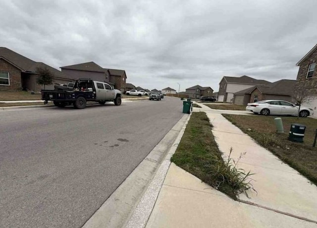 view of road featuring curbs, sidewalks, and a residential view