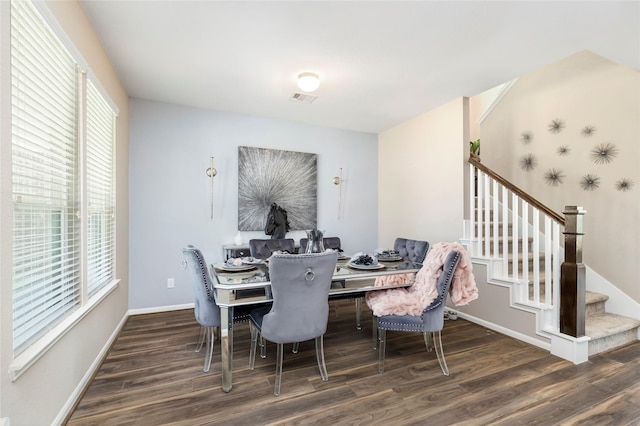 dining area featuring stairway, baseboards, visible vents, and wood finished floors