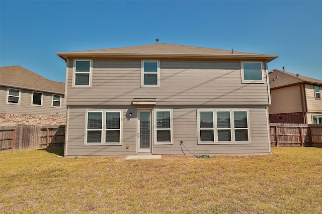 back of property with a yard and a fenced backyard