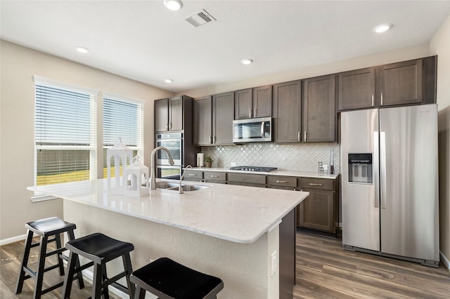 kitchen with tasteful backsplash, dark wood-style floors, visible vents, and appliances with stainless steel finishes