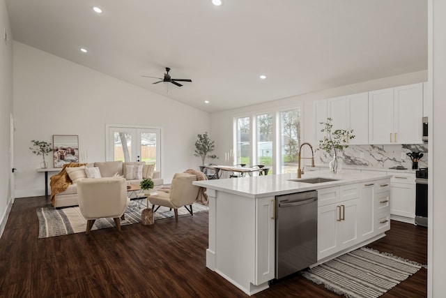 kitchen with open floor plan, appliances with stainless steel finishes, light countertops, and a sink