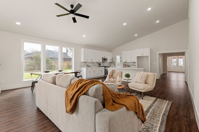 living room with high vaulted ceiling, dark wood finished floors, recessed lighting, baseboards, and ceiling fan