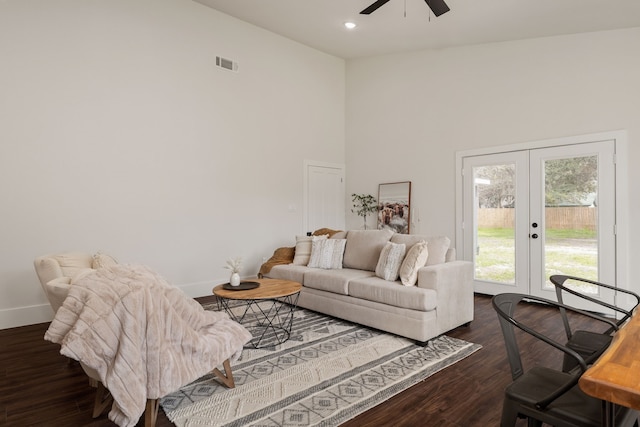 living room featuring baseboards, visible vents, dark wood-style flooring, french doors, and a towering ceiling