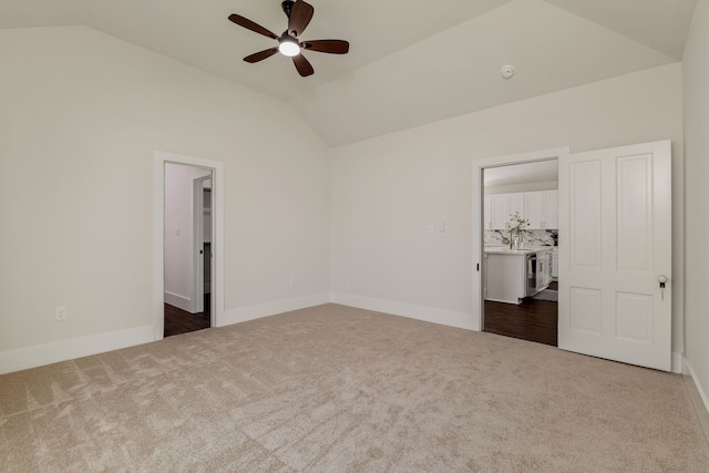 empty room featuring vaulted ceiling, baseboards, ceiling fan, and carpet floors