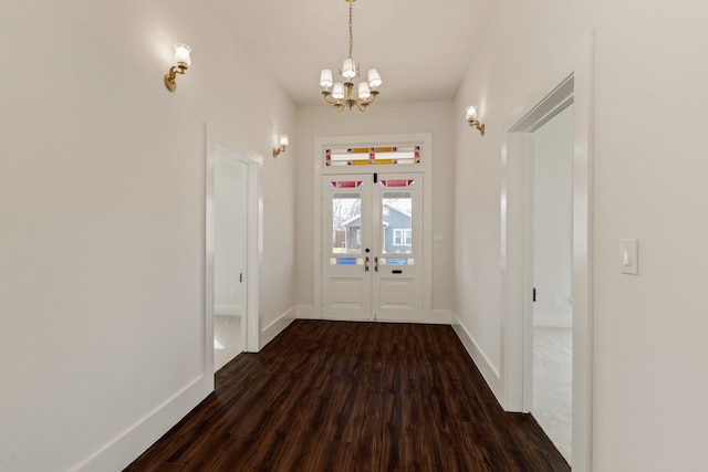 entrance foyer featuring dark wood finished floors, baseboards, and a chandelier