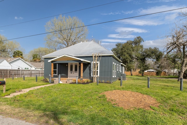 view of front facade featuring french doors, board and batten siding, a front lawn, and fence