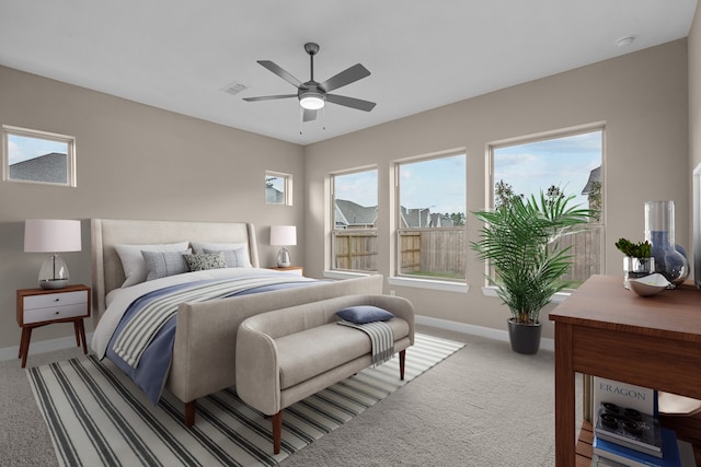 carpeted bedroom with visible vents, a ceiling fan, and baseboards