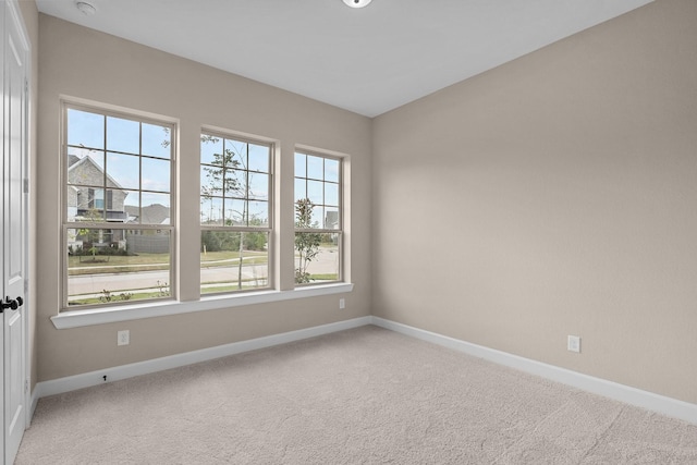 carpeted spare room featuring baseboards