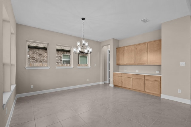 kitchen with baseboards, visible vents, hanging light fixtures, light countertops, and a notable chandelier