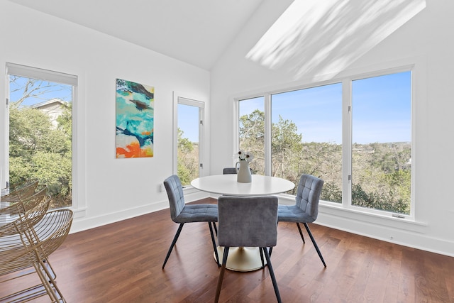 dining space featuring a healthy amount of sunlight, dark wood finished floors, and vaulted ceiling