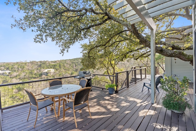 wooden terrace featuring outdoor dining area and a grill