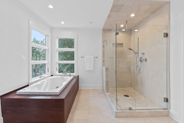 full bath with a tub with jets, baseboards, recessed lighting, tile patterned flooring, and a shower stall