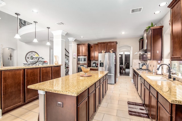 kitchen with a center island, visible vents, stainless steel appliances, and a sink