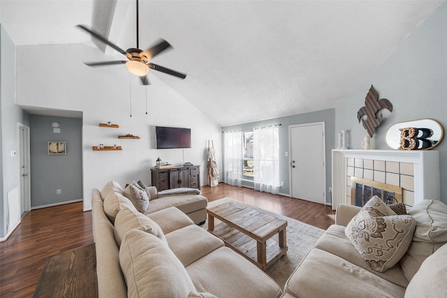 living room with a textured ceiling, wood finished floors, a fireplace, baseboards, and ceiling fan