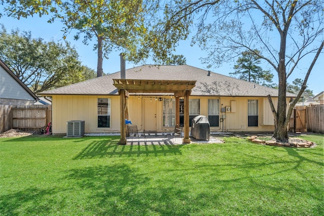 rear view of house featuring a patio, a fenced backyard, a yard, roof with shingles, and central AC unit