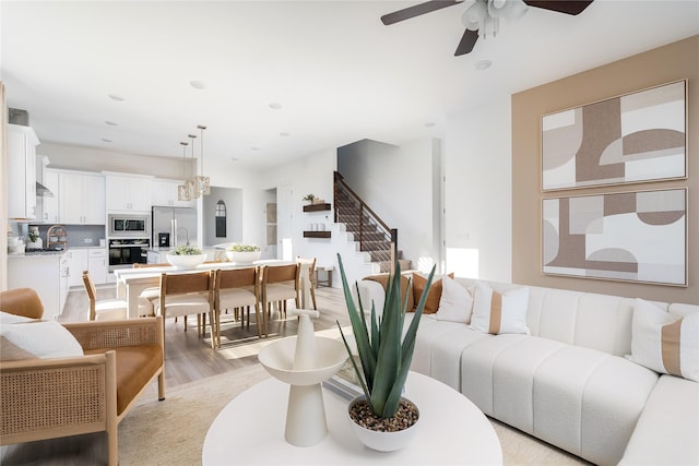 living area featuring light wood finished floors, recessed lighting, stairs, and ceiling fan