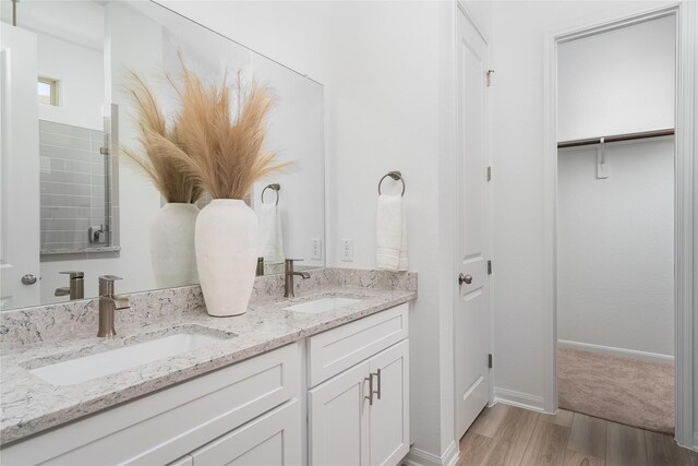 26711 Grandiflora Dr, Magnolia, TX 77355 - bathroom with wood finished floors, double vanity, and baseboards