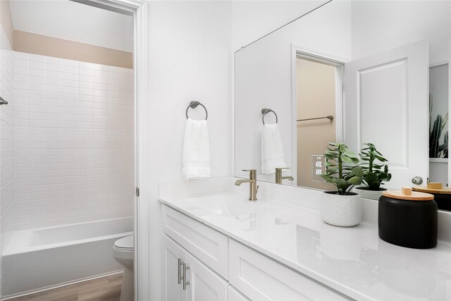 bathroom with shower / bathtub combination, toilet, vanity, and wood finished floors